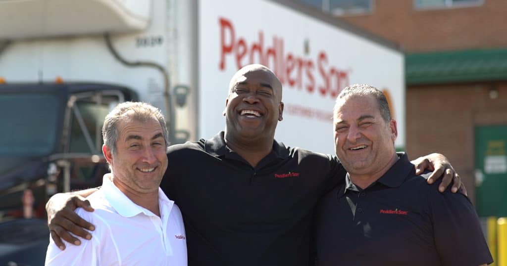 our story, peddler's son employees smiling in front of truck