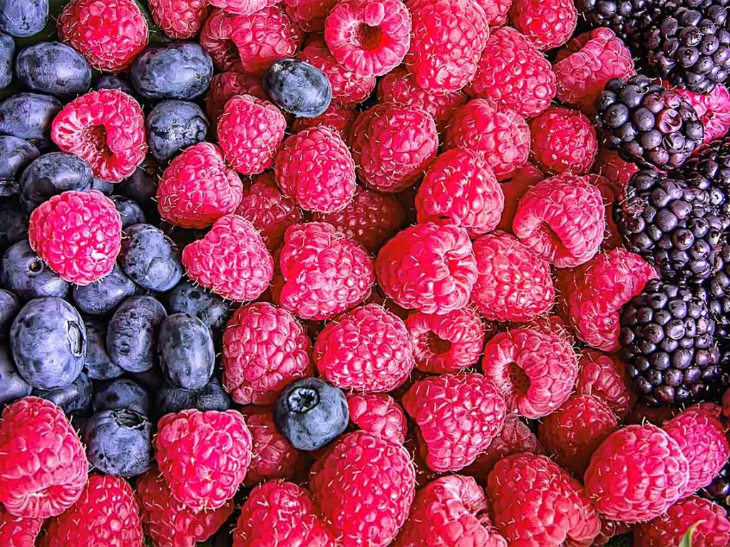 A pile of produce blueberries, raspberries, and blackberries